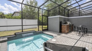A backyard with a swimming pool, a barbecue grill, and a seating area. - 4BR Le Reve Resort Pool Near Disney & Universal (Kissimmee)