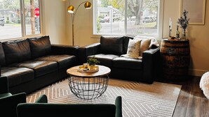 En moderne stue med en modulsofa, et rundt sofabord og en gulvlampe.