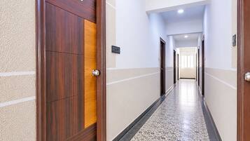 A hotel corridor with a wooden door marked '402' and a tiled floor.