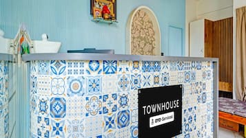A reception desk with a sign indicating it is a townhouse and offers 24-hour service.