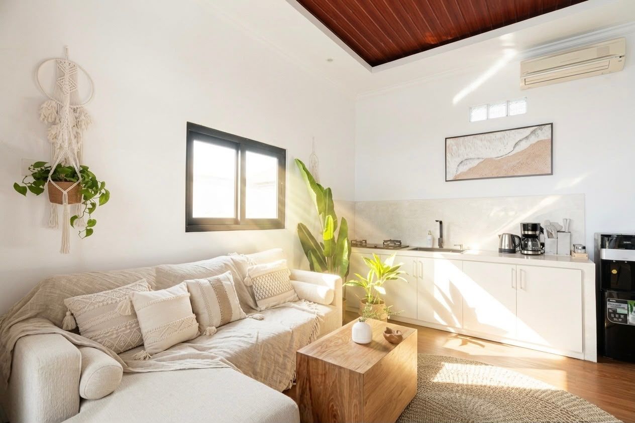A modern living room with a sofa, coffee table, and plants.