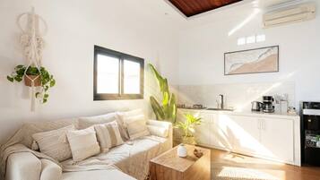 A modern living room with a sofa, coffee table, and plants.