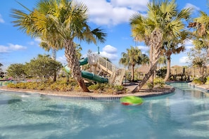 A pool area with palm trees, a water slide, and a bridge. - 4BD/3BA Family Escape | Private Pool near Disney (Davenport)