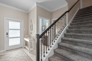 Un escalier avec une rampe noire et une plateforme recouverte de moquette.