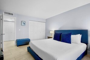 Ein Schlafzimmer mit einem großen Bett, einer Bank, einem Nachttisch und einem Wandheizkörper.