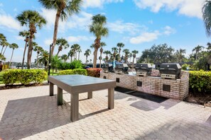 Eine Terrasse im Freien mit Tisch und Grillstation.