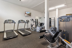A gym with treadmills, elliptical machines, and weightlifting equipment. - Harbor Towers 515 in Siesta Key (Siesta Key)