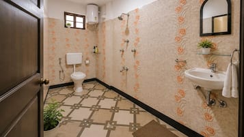 Un baño con inodoro, lavamanos, ducha y una planta en maceta.
