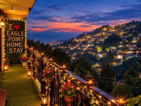 A balcony with a sign reading 'I ♥ EAGLE POINT HOME STAY,' surrounded by string lights and potted plants.