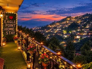 Ein Balkon mit einem Schild, auf dem 'I ♥ EAGLE POINT HOME STAY' steht, umgeben von Lichterketten und Topfpflanzen.