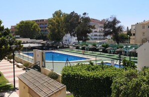 A residential area with a swimming pool, a tennis court, and a small building with a tiled roof. - Apartment With Pool and Golf Course Views in Roquetas de Mar (Roquetas de Mar)