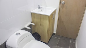 A compact bathroom with a toilet, a sink, and a cabinet. - 41 September Promo in The Coolest Neighborhood (Medellín)