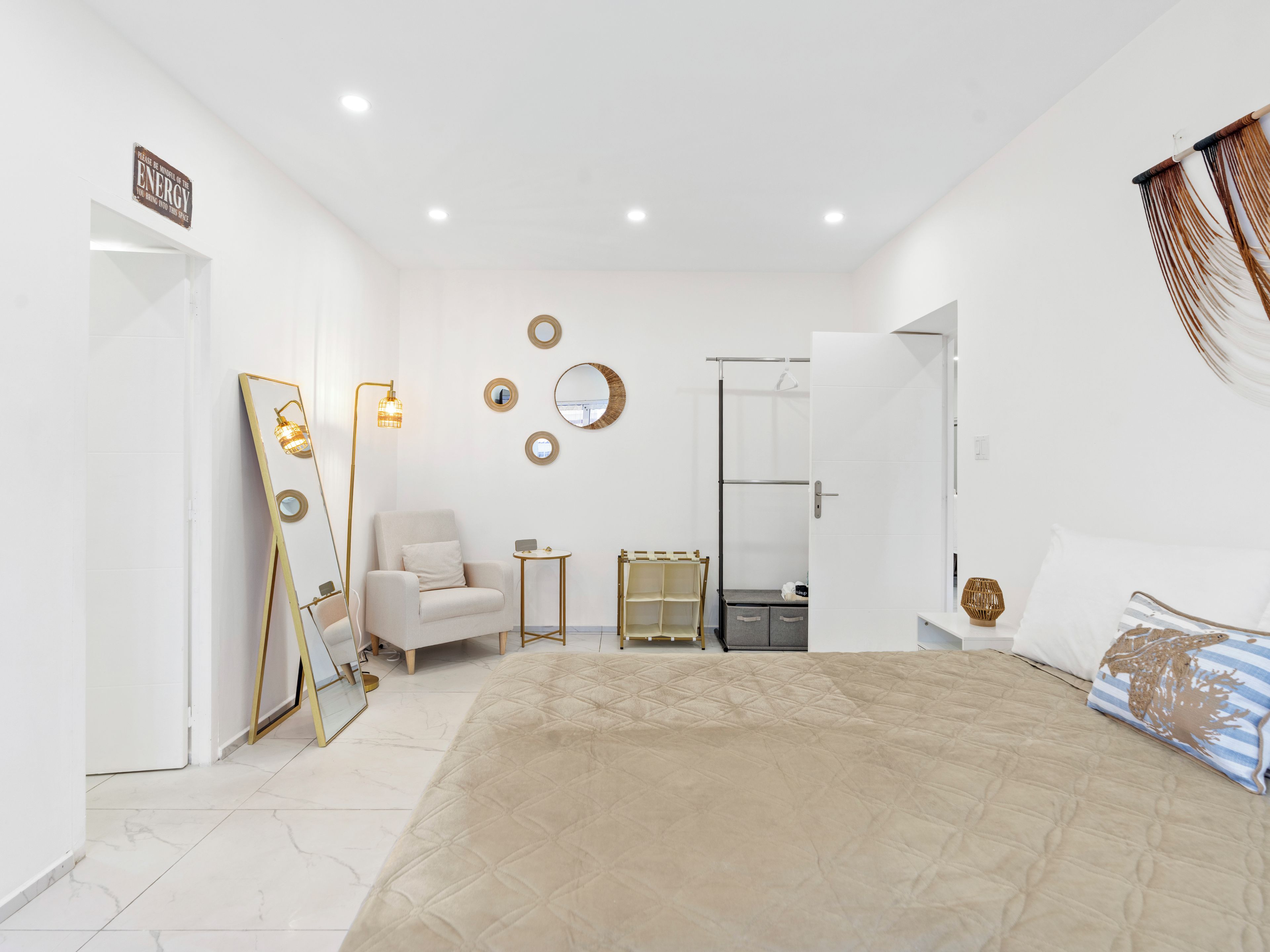 Quarto moderno com cama grande, toucador com espelho, cadeira e closet espaçoso.