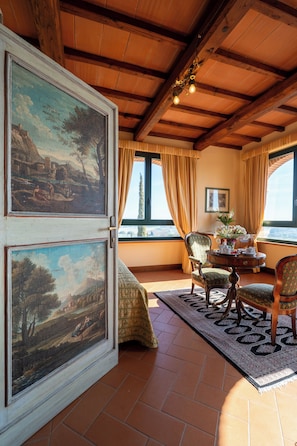 Une pièce dotée d’un grand plafond en bois, d’un coin repas avec une table et des chaises, et de deux tableaux encadrés accrochés au mur.