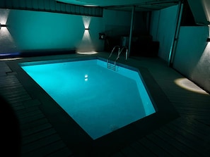 A swimming pool with a metal ladder, surrounded by a wooden deck. - 2-bedroom villa in adorable Mitzpe Ramon with privet pool and beautiful garden (Mitzpe Ramon)