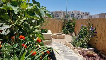 Un sendero en un jardín con plantas y una valla de madera.