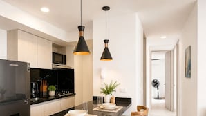 A modern kitchen with a central island, black appliances, and pendant lighting. - Tropical Midnight | Sunset Views & Pool, Wi-Fi (Cartagena)