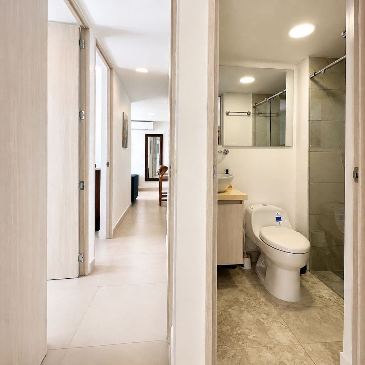A modern bathroom with a toilet, sink, and shower.