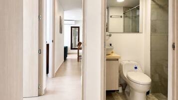 A modern bathroom with a toilet, sink, and shower.