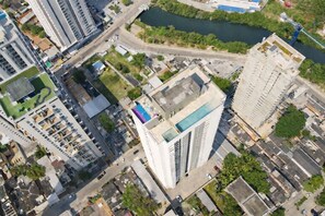 Ein Hochhaus mit Pool auf dem Dach, umgeben von anderen Gebäuden und einem Fluss.