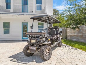 A golf cart parked in front of a building with a number '69' on the door. - Shellbelle: Steps to Beach, Heated Pool & Hot Spa, Free Golf Cart, 3 Game Rooms (Miramar Beach)
