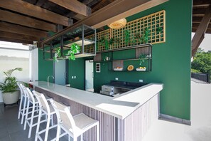 Ein Außenbereich mit Bar, Sitzgelegenheiten und Pflanzen.