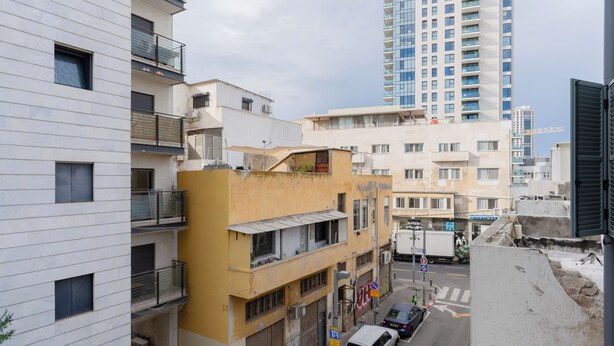 A multi-story building with balconies and a street in front. - Blueground - Historical Preserved Estate (Tel Aviv-Yafo)