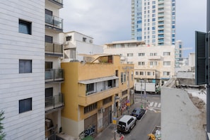 A multi-story building with balconies and a street in front. - Blueground - Historical Preserved Estate (Tel Aviv-Yafo)