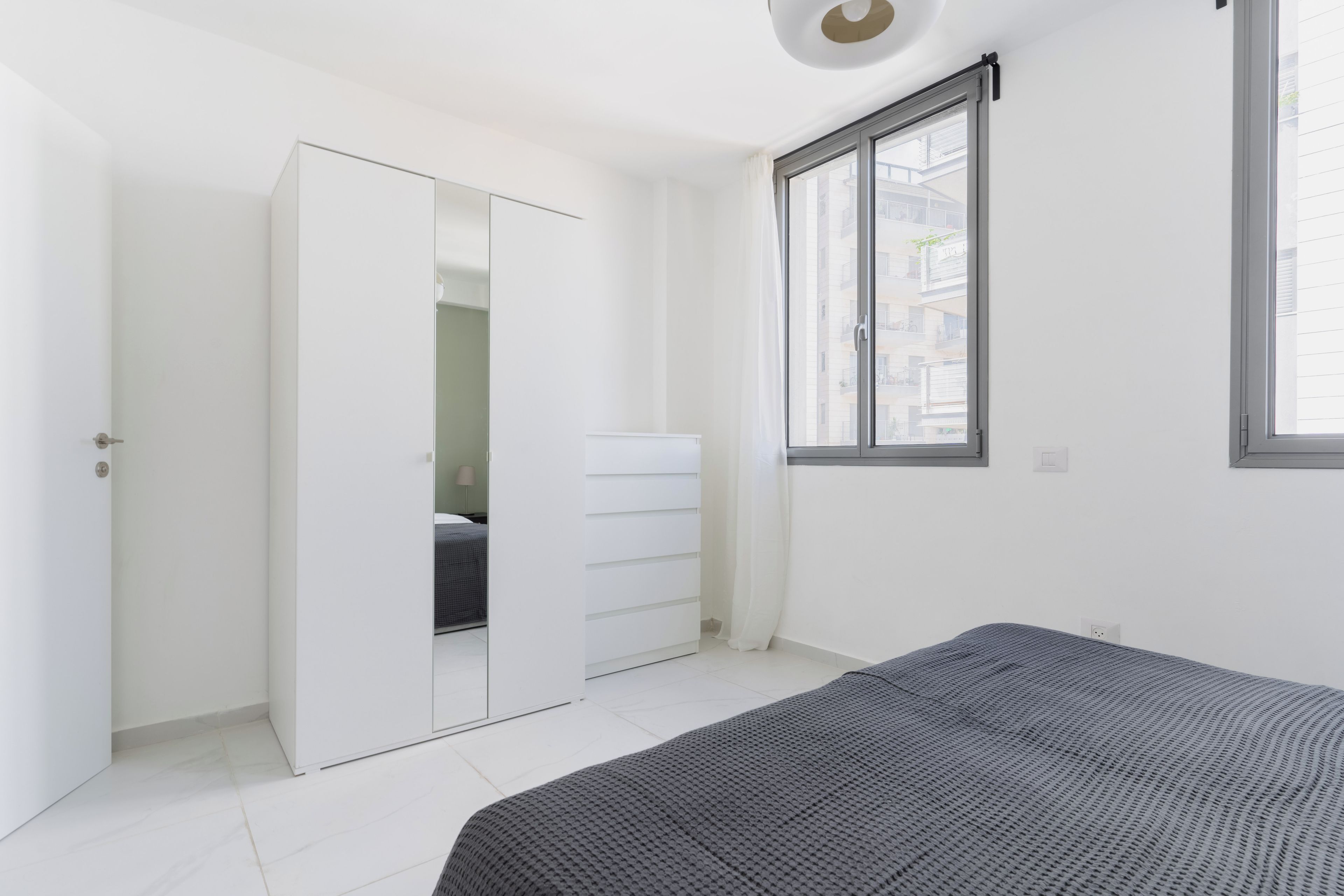 Quarto com uma cama, guarda-roupa, janela e porta.