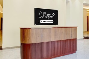 Una mesa de recepción con un cartel encima que dice 'Collection' y 'YO-Serviced'.