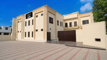 A modern building with a flat facade, multiple windows, and a gated entrance.