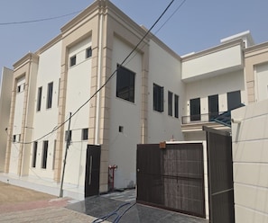 A multi-story residential building with a symmetrical facade, multiple windows, and a gated entrance. - Collection O City Centre Sapror (Phagwara)