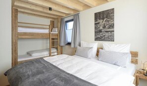 A bunk bed with a ladder, a single bed with checkered pillows, and a framed picture on the wall. - Wetzstoa Chalet in Unterammergau (Unterammergau)