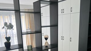 Een moderne woonkamer met een hoekbank, een salontafel en een ingebouwde boekenkast met decoratieve objecten.