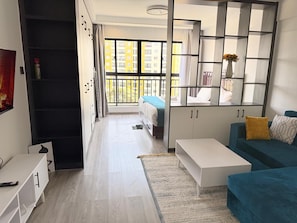 A modern apartment with a bed, a sofa, a coffee table, and a wardrobe. - Inaya Haven Kileleshwa (Nairobi)