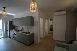 A modern kitchen with grey cabinets, a built-in oven, and a stainless steel sink. There are two pendant lights hanging above the counter. - Brezza di Mare - Sea, Passion, Relax (Terracina)