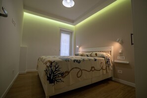A bedroom with a bed, a window, and a wall-mounted light fixture. - Brezza di Mare - Sea, Passion, Relax (Terracina)
