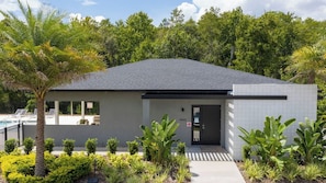 A modern building with a flat roof, a door, and a small porch area. - Prime Location 4BR Le Reve with Pool Near Disney (Kissimmee)