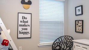 A room with a window, a framed motivational quote, and Mickey Mouse-themed decor. - Prime Location 4BR Le Reve with Pool Near Disney (Kissimmee)
