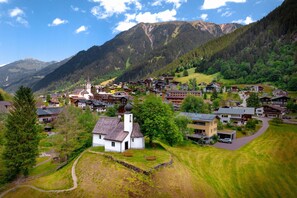 A mountain village with traditional buildings, a church, and a clear view of the surrounding mountains. - Modern Suite With Outdoor Sauna (Gaschurn)