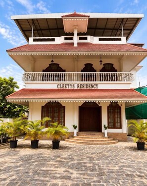 Un immeuble de deux étages doté d’un balcon et d’une enseigne sur laquelle on peut lire : « Cleetys Residency ».