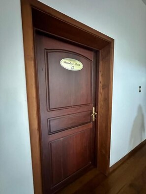 Una puerta de madera con una placa que indica 'Henderson Suite 21'.