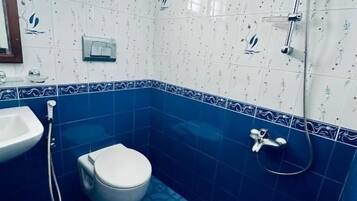 Een badkamer met toilet, wastafel en douche.