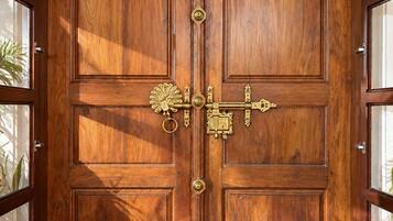 Una gran puerta doble de madera con un tirador de bronce y una cerradura decorativa.