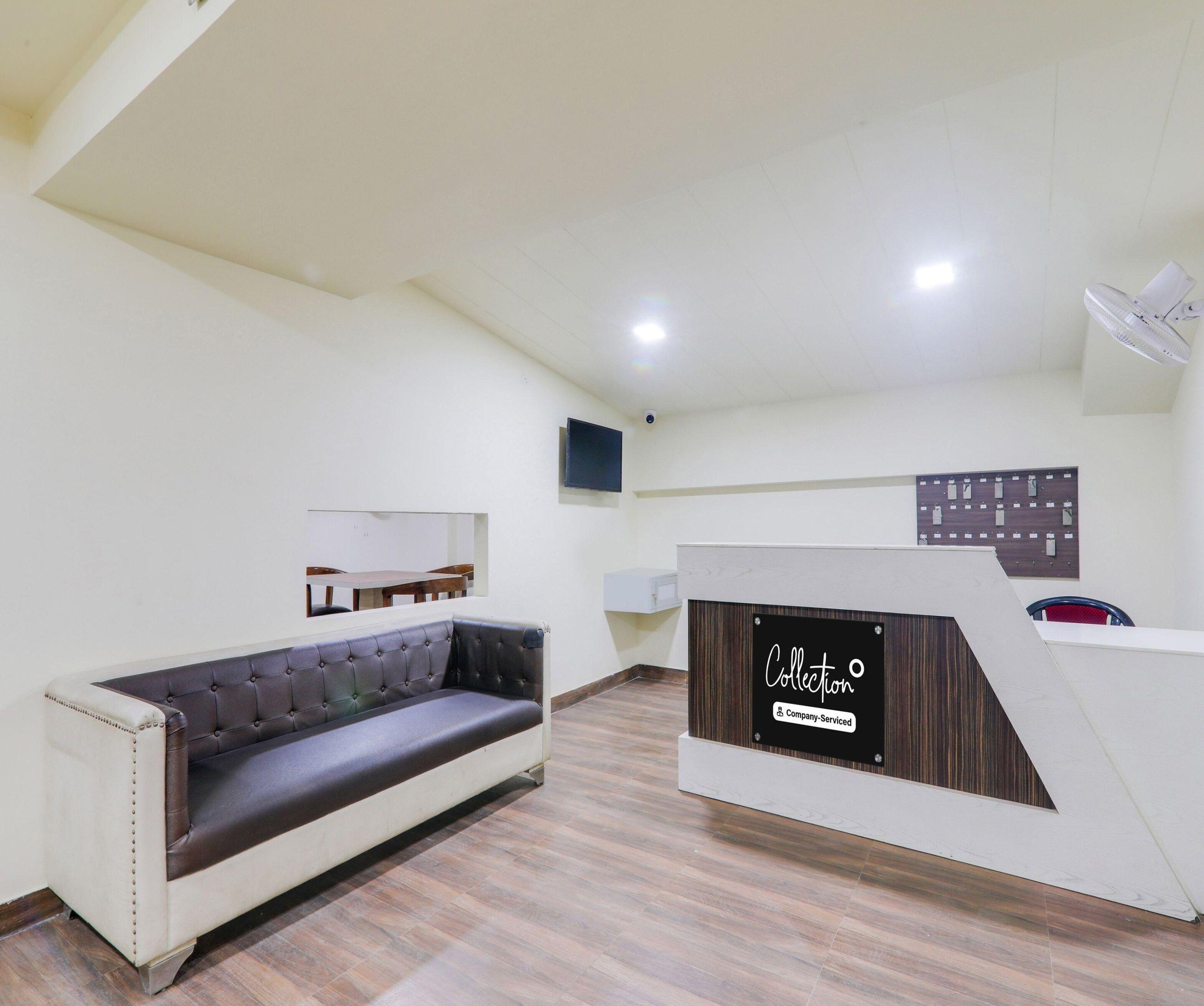 A modern interior with a sofa, a reception desk, and a mounted television.