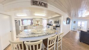 A kitchen with a large island, white cabinets, stainless steel appliances, and a sign that says "BEACH". - 2 Oceanfront Single Family Huge Homes, 500 ft apart, 2 Private Pools, Sleeps 60 (North Myrtle Beach)