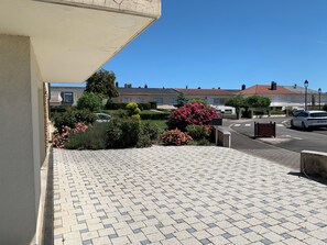 A residential street with houses, a paved driveway, and a clear blue sky.