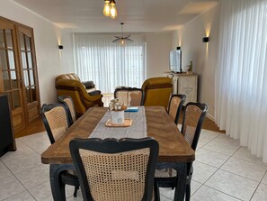 A dining room with a wooden table, six chairs, and a decorative centerpiece.