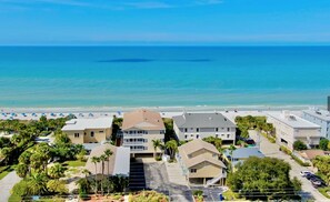 A coastal residential area with beachfront properties, a clear sky, and a calm sea. - Ground Floor, 3-bedroom condo in Indian Rocks Beach, Sunset Paradise, Gulf Side (Indian Rocks Beach)