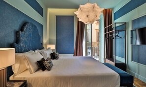 Une chambre d’hôtel avec un grand lit, une table de chevet, une lampe, un luminaire au plafond et une vue sur l’extérieur.